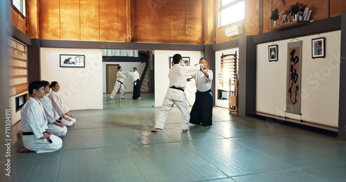 Aikido, sensei and Japanese students with training, fitness and action in class for defence or technique. Martial arts, people or fighting with discipline, uniform or confidence for culture and skill