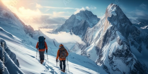 Two hikers ascending a snowy mountain range