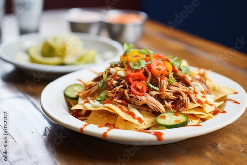 nachos with pulled pork and barbeque sauce drizzle
