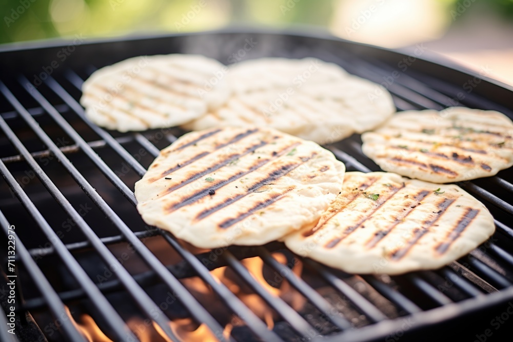 grilled naan with grill marks, placed on a cooking grid grilled naan with grill marks, placed on a cooking grid