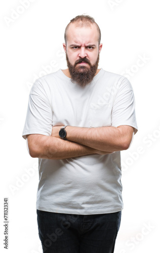 Young caucasian hipster man wearing casual t-shirt over isolated background skeptic and nervous, disapproving expression on face with crossed arms. Negative person.