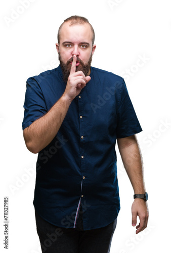 Young caucasian hipster man over isolated background asking to be quiet with finger on lips. Silence and secret concept.