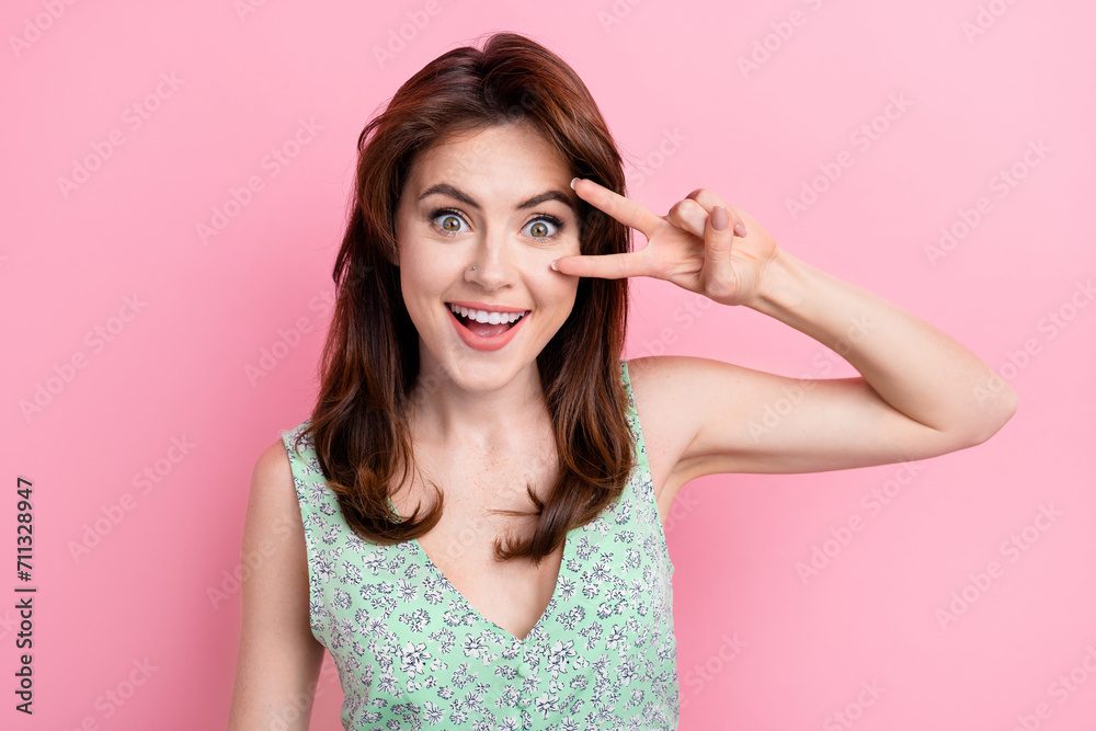 Photo of cheerful carefree cute girl wear stylish print outfit arm touch face v-sign isolated on vibrant pink color background Photo of cheerful carefree cute girl wear stylish print outfit arm touch face v-sign isolated on vibrant pink color background