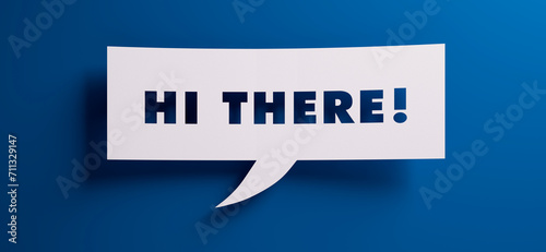 Speech bubble with the words hi there in front of a blue colored wall - 3D illustration