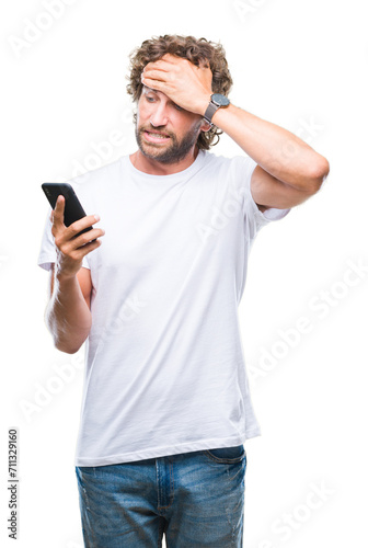 Handsome hispanic man model sending message texting using smartphone over isolated background stressed with hand on head, shocked with shame and surprise face, angry and frustrated. Fear and upset
