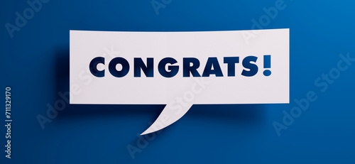 Speech bubble with the word congrats in front of a blue colored wall - 3D illustration