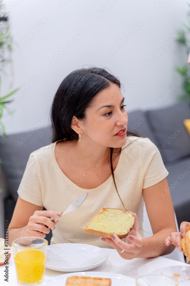 Woman applying butter to bread for her morning routine. Woman applying butter to bread for her morning routine.
