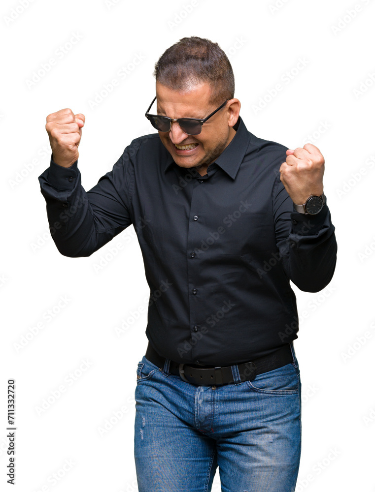 Middle age arab man wearing sunglasses over isolated background very happy and excited doing winner gesture with arms raised, smiling and screaming for success. Celebration concept.