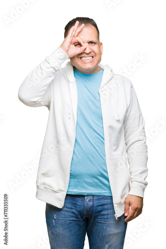 Middle age arab man wearing sweatshirt over isolated background doing ok gesture with hand smiling, eye looking through fingers with happy face.