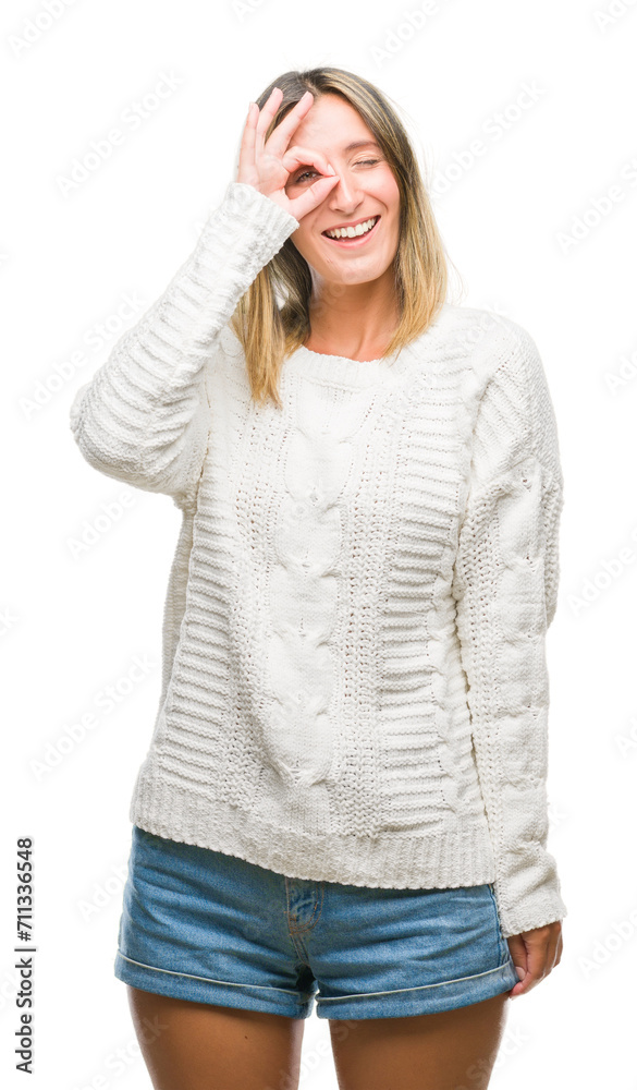 Young beautiful woman wearing winter sweater over isolated background doing ok gesture with hand smiling, eye looking through fingers with happy face. Young beautiful woman wearing winter sweater over isolated background doing ok gesture with hand smiling, eye looking through fingers with happy face.
