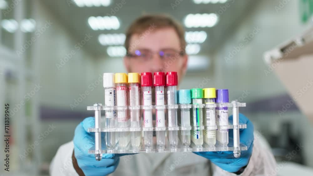 A scientist holds in his hands scientific laboratory test tubes for blood analysis. Clinic doctor, medical technician conducts laboratory testing of blood samples. A scientist holds in his hands scientific laboratory test tubes for blood analysis. Clinic doctor, medical technician conducts laboratory testing of blood samples.