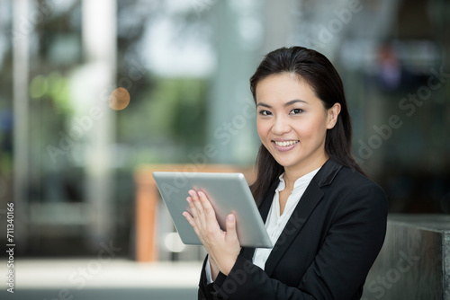 Happy Chinese busines woman using a tablet pc