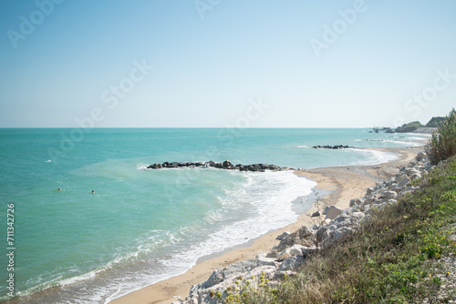 View of a turquoise water beach with a breakwater