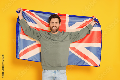 Man with flag of United Kingdom on yellow background