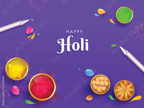 Top view of Indian Sweets  Dry Colors  Gulal  Filled Bowls and Pichkari  Colour Gun  and Water Balloons on Purple Floral Background for Holi Holi Celebration Concept.