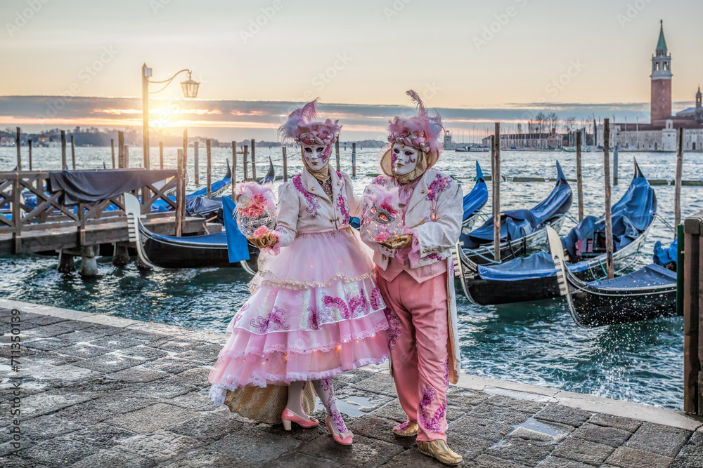 Colorful carnival masks at a traditional festival in Venice against gondolas, Italy - obrazy, fototapety, plakaty 