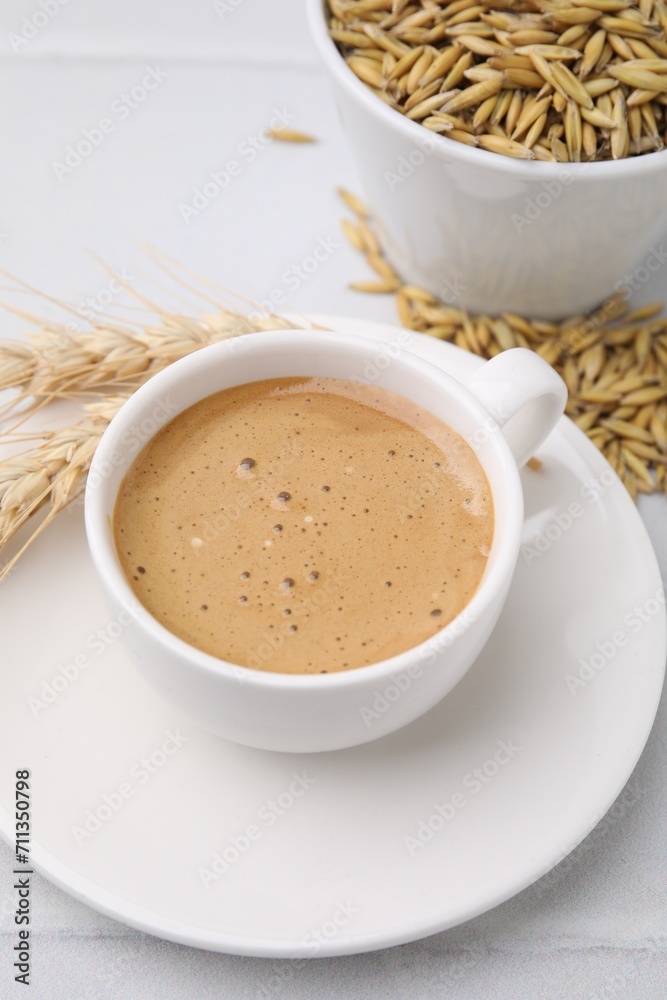 Cup of barley coffee, grains and spikes on white table, closeup Cup of barley coffee, grains and spikes on white table, closeup