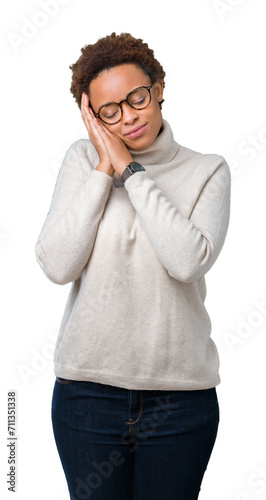 Young beautiful african american woman wearing glasses over isolated background sleeping tired dreaming and posing with hands together while smiling with closed eyes.