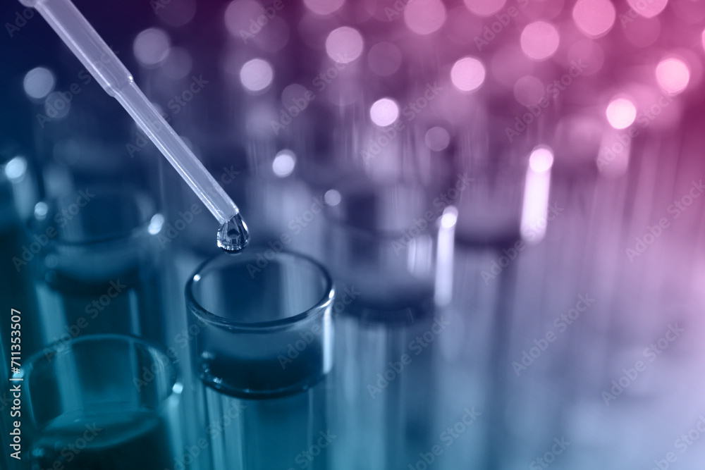 Dripping reagent into test tube with sample, closeup. Color toned Dripping reagent into test tube with sample, closeup. Color toned
