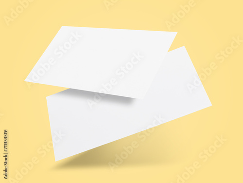 Blank business cards in air on light yellow background. Mockup for design
