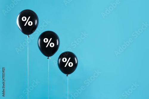 Discount offer. Black balloons with percent sign on light blue background, space for text