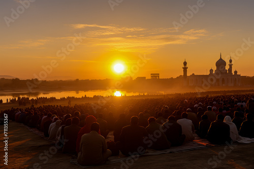 A large gathering of people sitting and facing towards a beautiful mosque during sunset, possibly observing a religious event or holiday, Eid Prayer