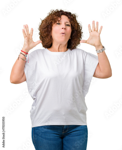 Beautiful middle ager senior woman wearing white t-shirt over isolated background celebrating crazy and amazed for success with arms raised and open eyes screaming excited. Winner concept