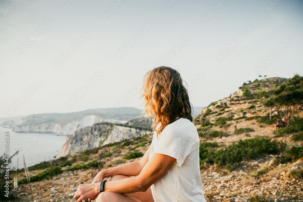 Naklejka premium woman tourist relaxing and watching rocks in the sea
