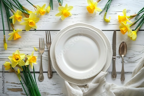 spring table setting on a white table with daffodi flowers photo