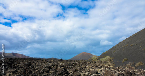 Spectacular view of the Fire Mountains at Timanfaya National Park, this unique area consisting entirely of volcanic soils. Volcanic landscape in a sea of ​​lava. Plenty space of text. Lanzarote, Spain