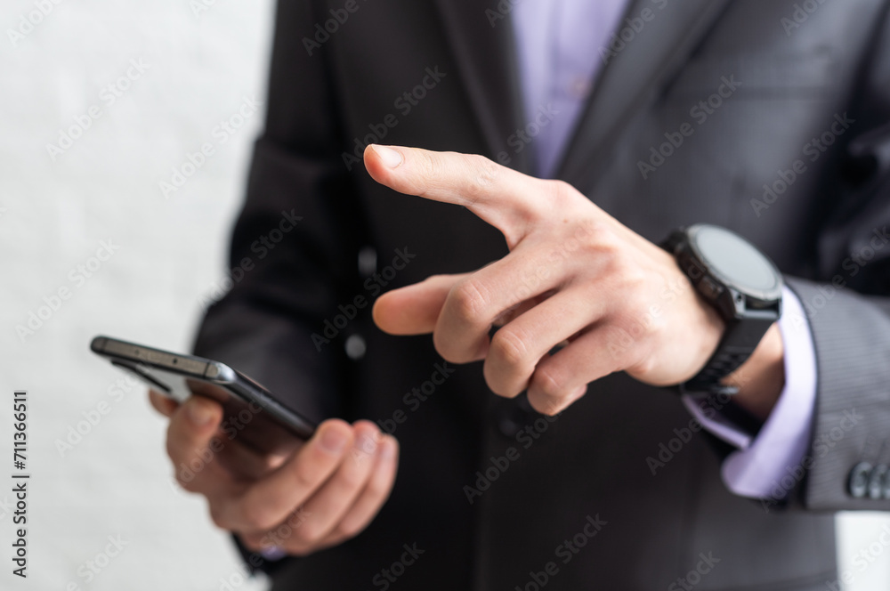 Businessman in the suit is using smartphone Businessman in the suit is using smartphone