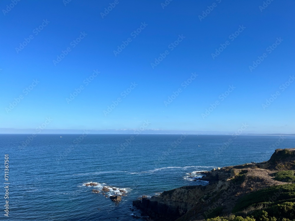 Ocean coast, clear blue sky, blue horizon, natural colors, no people