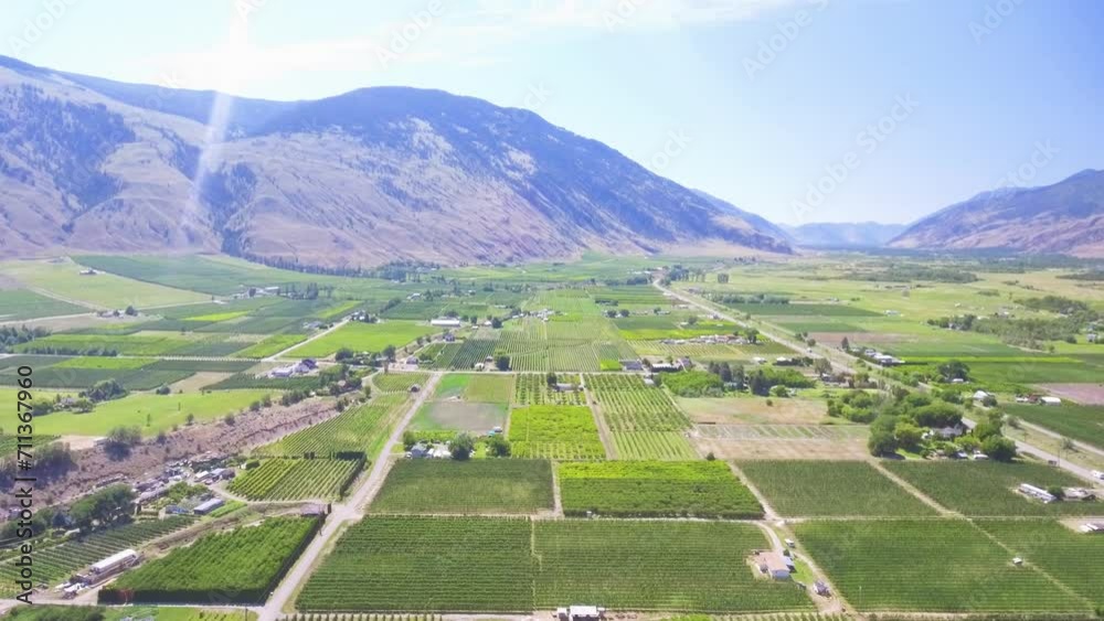 Drone shot over the valley of British Columbia with stunning green crops on the farmers fields surrounded by the Rocky mountains. Drone shot over the valley of British Columbia with stunning green crops on the farmers fields surrounded by the Rocky mountains.