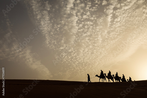 Silhouette of camel caravan with beautiful clouds in background in Sahara, Merzouga, Morocco