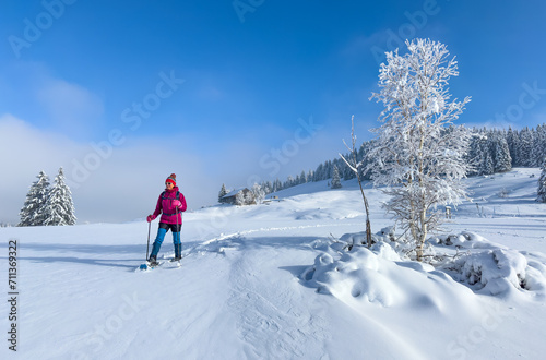 nice and active senior woman hiking with snow shoes in deep powder snow in the Allgau alps, Bavaria, Germany © Uwe