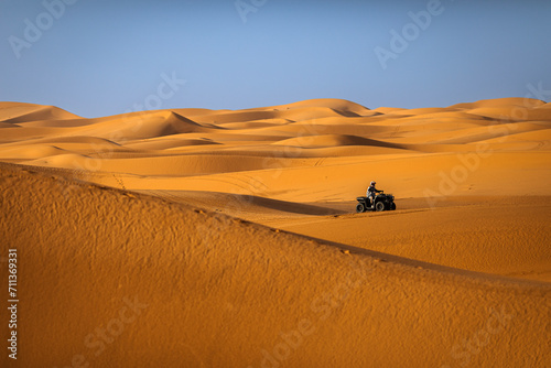 Fototapeta Naklejka Na Ścianę i Meble -  ATV machine running on desert dunes in Sahara, Merzouga, Morocco