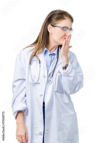 Middle age mature doctor woman wearing medical coat over isolated background bored yawning tired covering mouth with hand. Restless and sleepiness.
