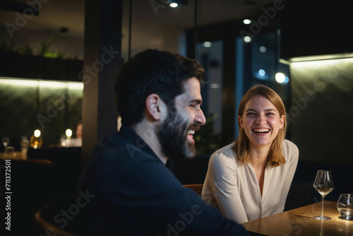 Couple in a fancy restaurant, or a bar, smiling and laughing happily.