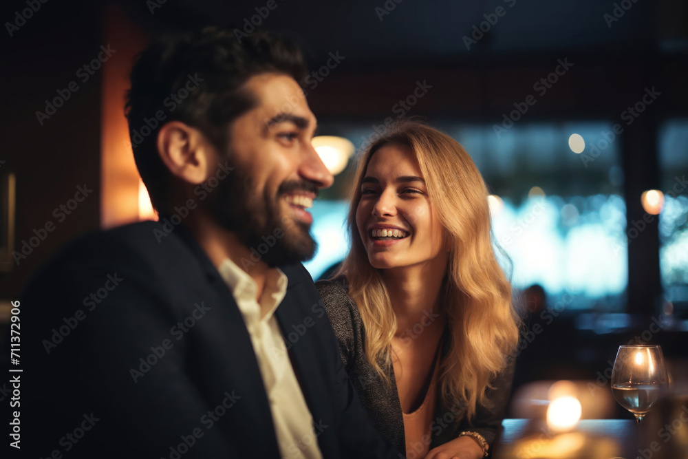 Couple in a fancy restaurant, or a bar, smiling and laughing happily.