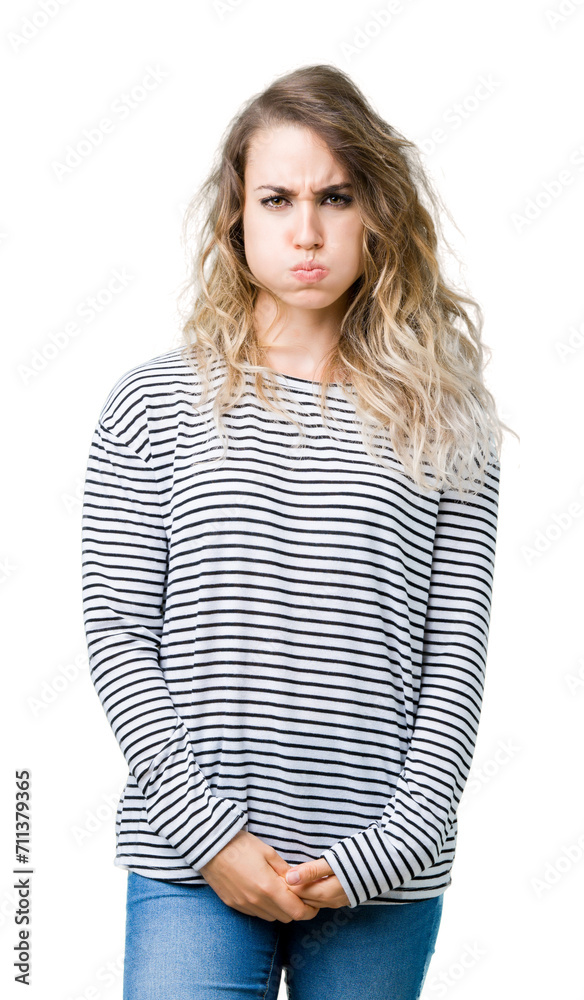 Beautiful young blonde woman wearing stripes sweater over isolated background puffing cheeks with funny face. Mouth inflated with air, crazy expression. Beautiful young blonde woman wearing stripes sweater over isolated background puffing cheeks with funny face. Mouth inflated with air, crazy expression.