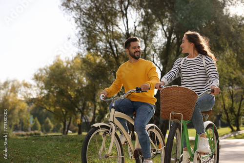 Photography Beautiful couple riding bicycles in park, space for text