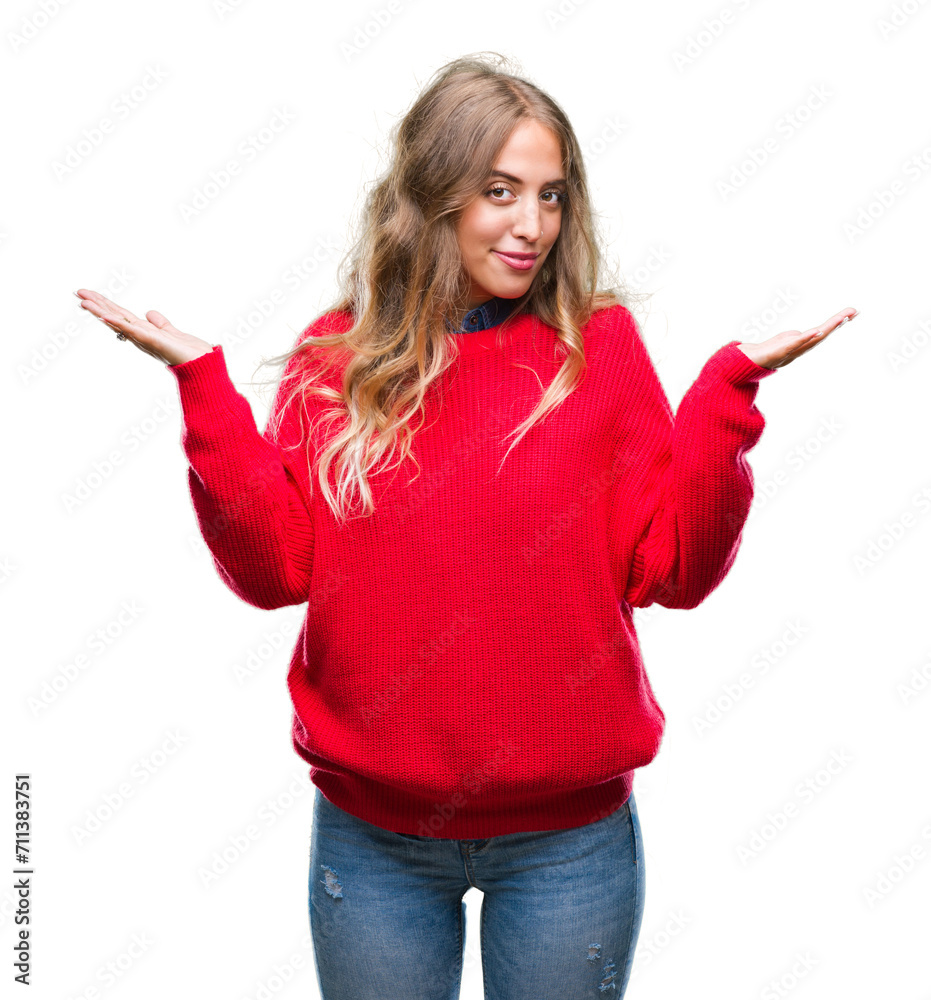 Beautiful young blonde woman wearing winter sweater over isolated background clueless and confused expression with arms and hands raised. Doubt concept. Beautiful young blonde woman wearing winter sweater over isolated background clueless and confused expression with arms and hands raised. Doubt concept.