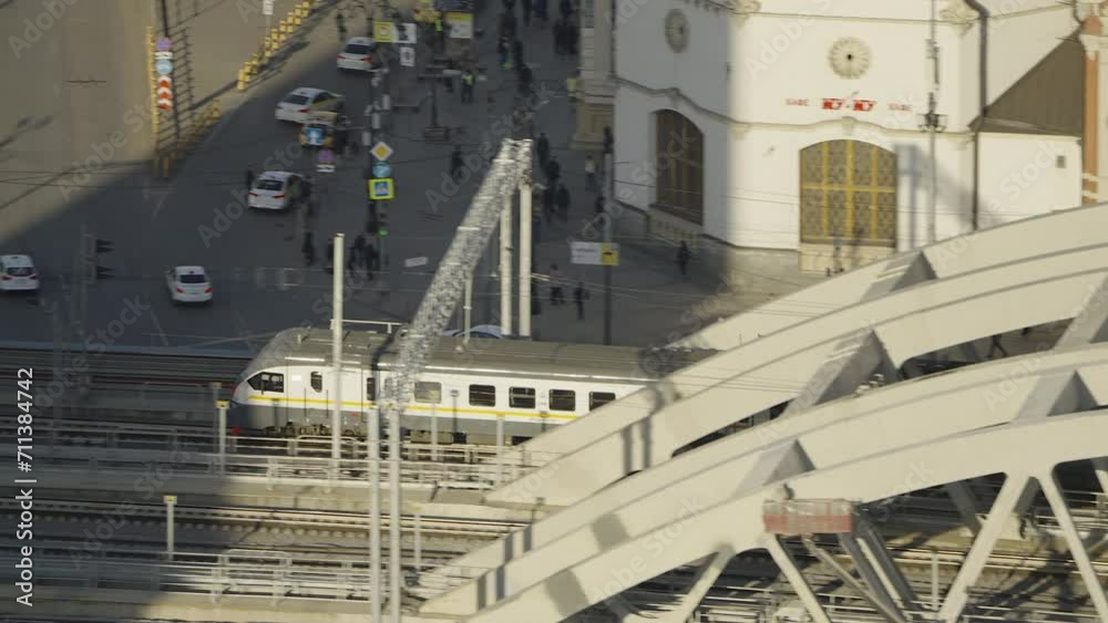 A modern beautiful passenger commuter train rides over a bridge in the center of Moscow in summer at sunrise A modern beautiful passenger commuter train rides over a bridge in the center of Moscow in summer at sunrise
