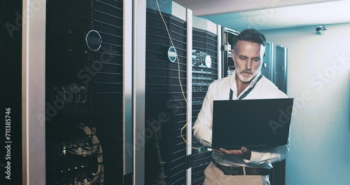 Mature man in server room with laptop, network maintenance and engineer in digital storage for database update. Tech employee, system administration and technician online in data center with computer photo
