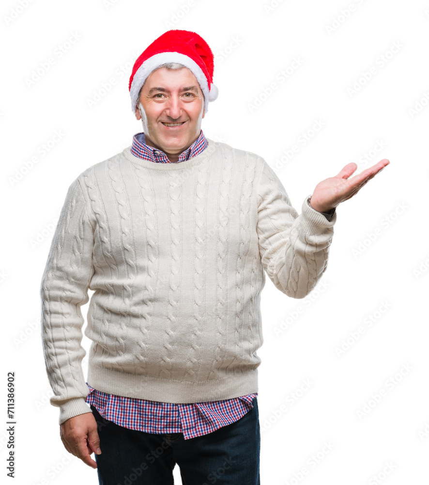 Handsome senior man wearing christmas hat over isolated background smiling cheerful presenting and pointing with palm of hand looking at the camera. Handsome senior man wearing christmas hat over isolated background smiling cheerful presenting and pointing with palm of hand looking at the camera.