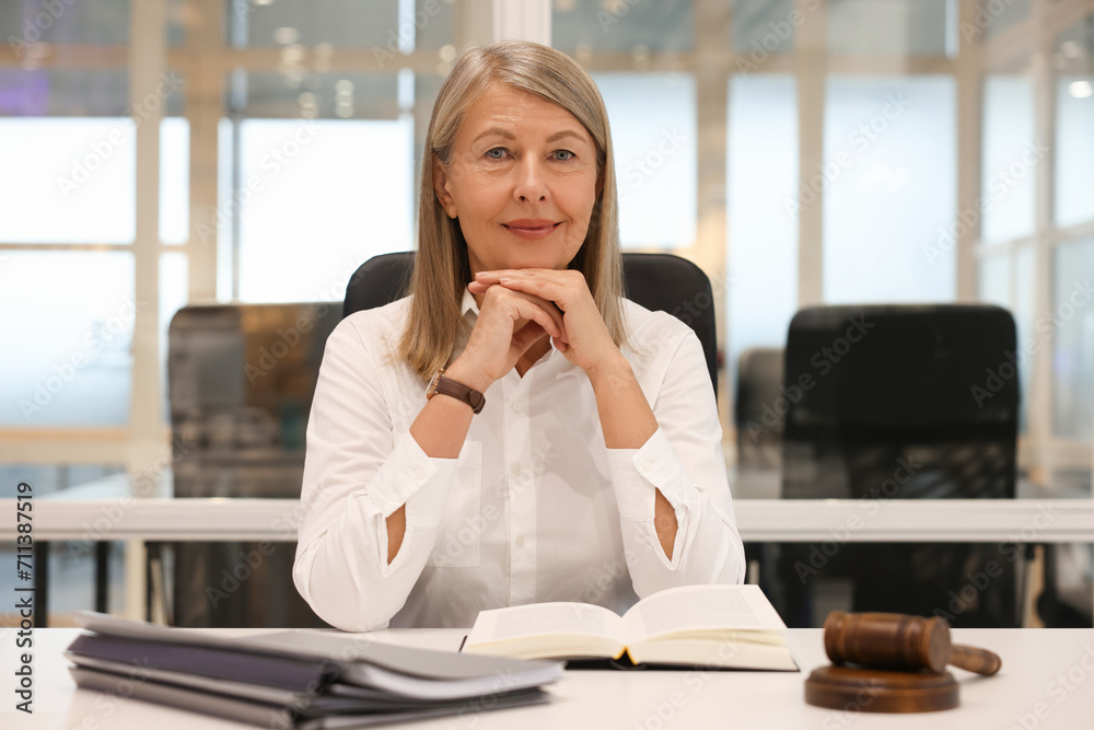Portrait of confident lawyer working at table in office Portrait of confident lawyer working at table in office