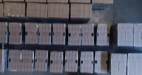 High angle view of forklifts moving boxes in warehouse against white background