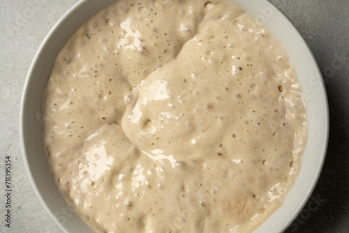 Top view sourdough starter in a bowl. Home baking, wild east, fermented food. photo