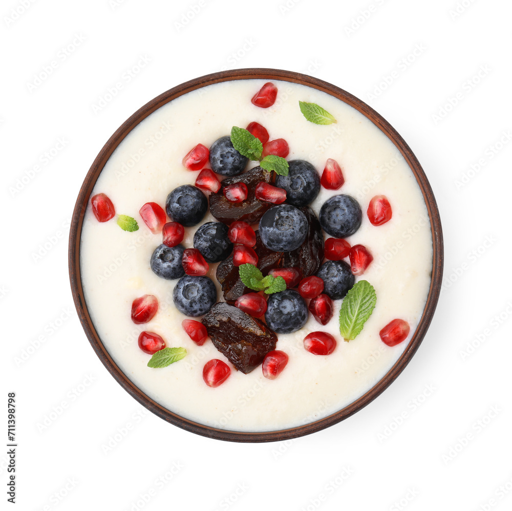 Delicious semolina pudding with blueberries, pomegranate, dates and mint in bowl isolated on white, top view Delicious semolina pudding with blueberries, pomegranate, dates and mint in bowl isolated on white, top view