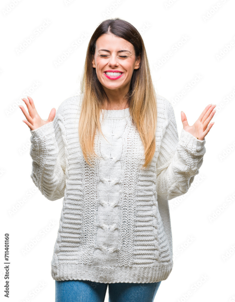Young beautiful woman casual white sweater over isolated background celebrating mad and crazy for success with arms raised and closed eyes screaming excited. Winner concept Young beautiful woman casual white sweater over isolated background celebrating mad and crazy for success with arms raised and closed eyes screaming excited. Winner concept